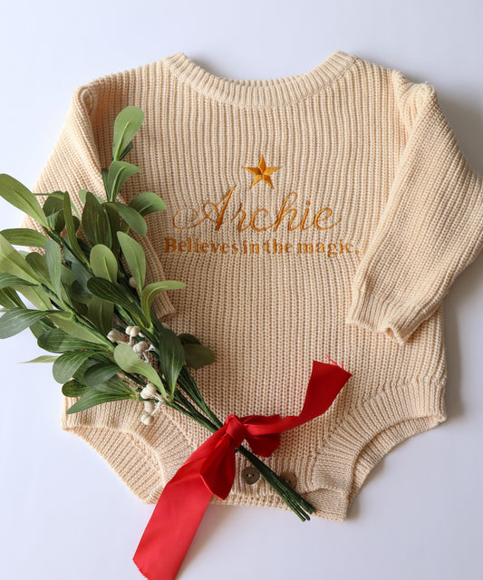 Beige Personalised baby romper with a star embroidery design with the words believes in the magic