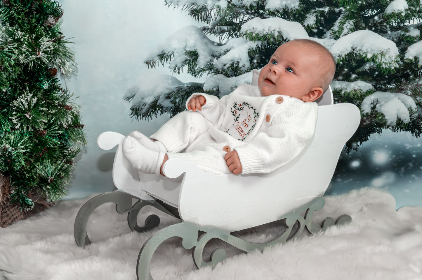 Baby Knit onesie with a wreath embroidery design with the words my first christmas