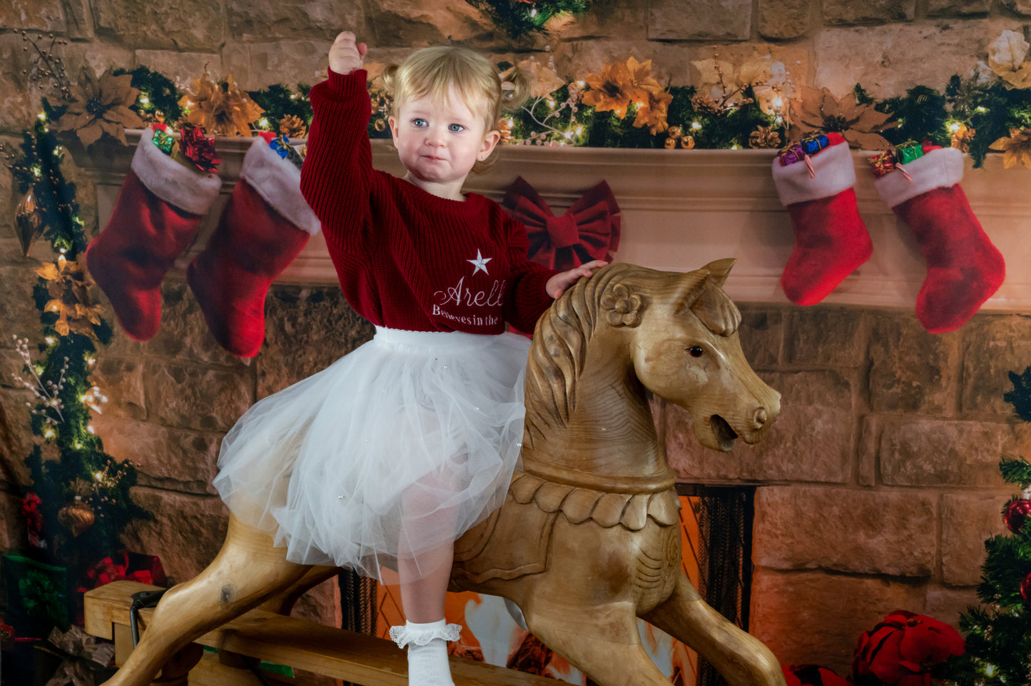 Embroidered kids knit sweater , personalised with the childs name, a star and the words believes in the magic.