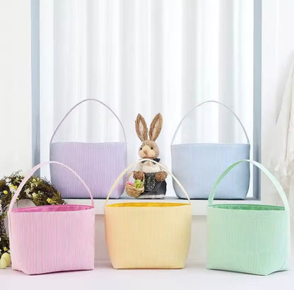 Set of pastel-colored ribbed fabric baskets with a stuffed rabbit toy in the center.