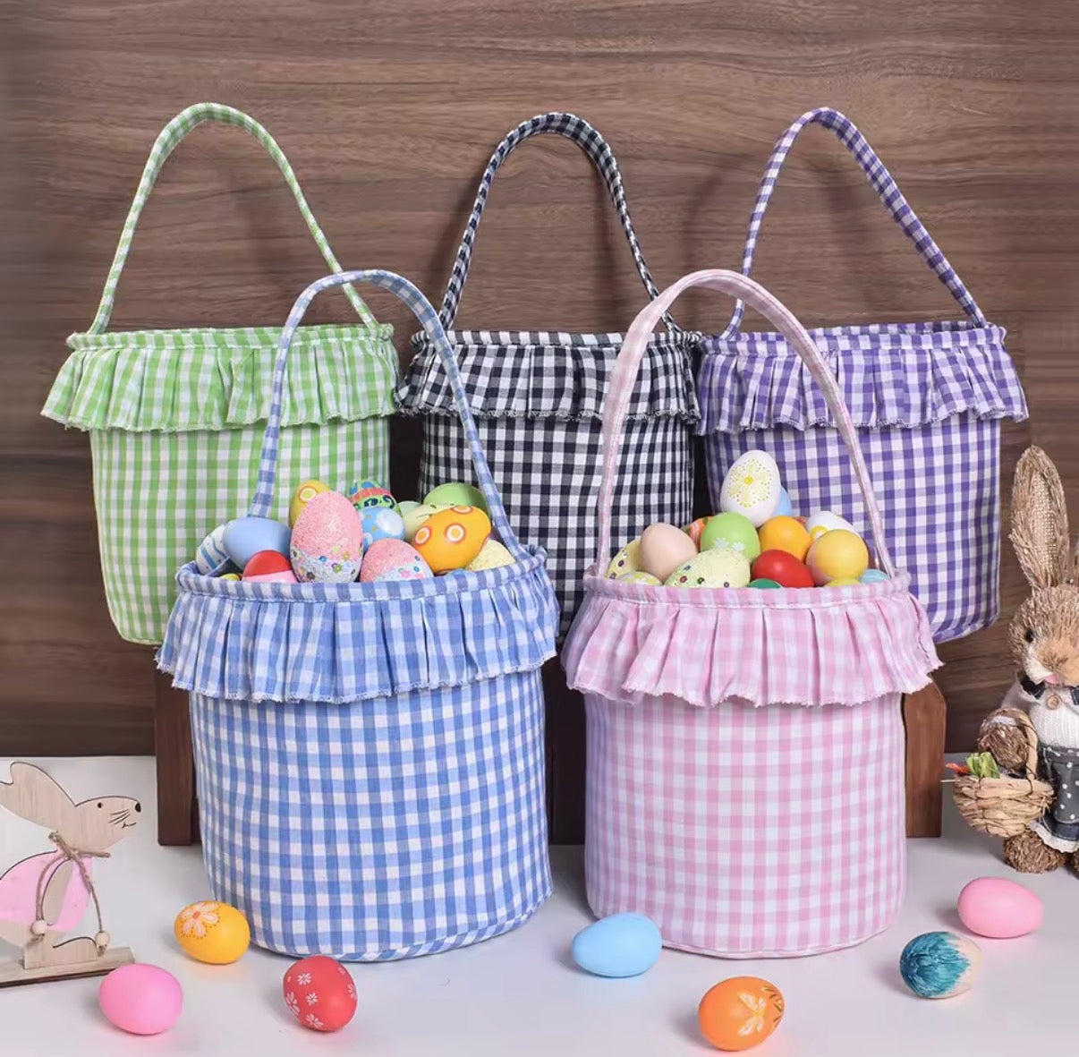 Set of colorful checkered Easter baskets with eggs on a wooden background