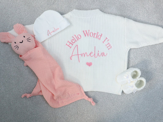 Baby outfit with 'Hello World I'm Amelia' text on a gray background