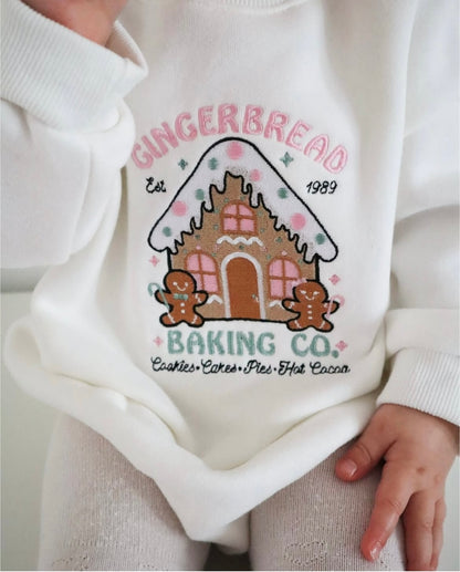 White baby romper with gingerbread-themed design and text.