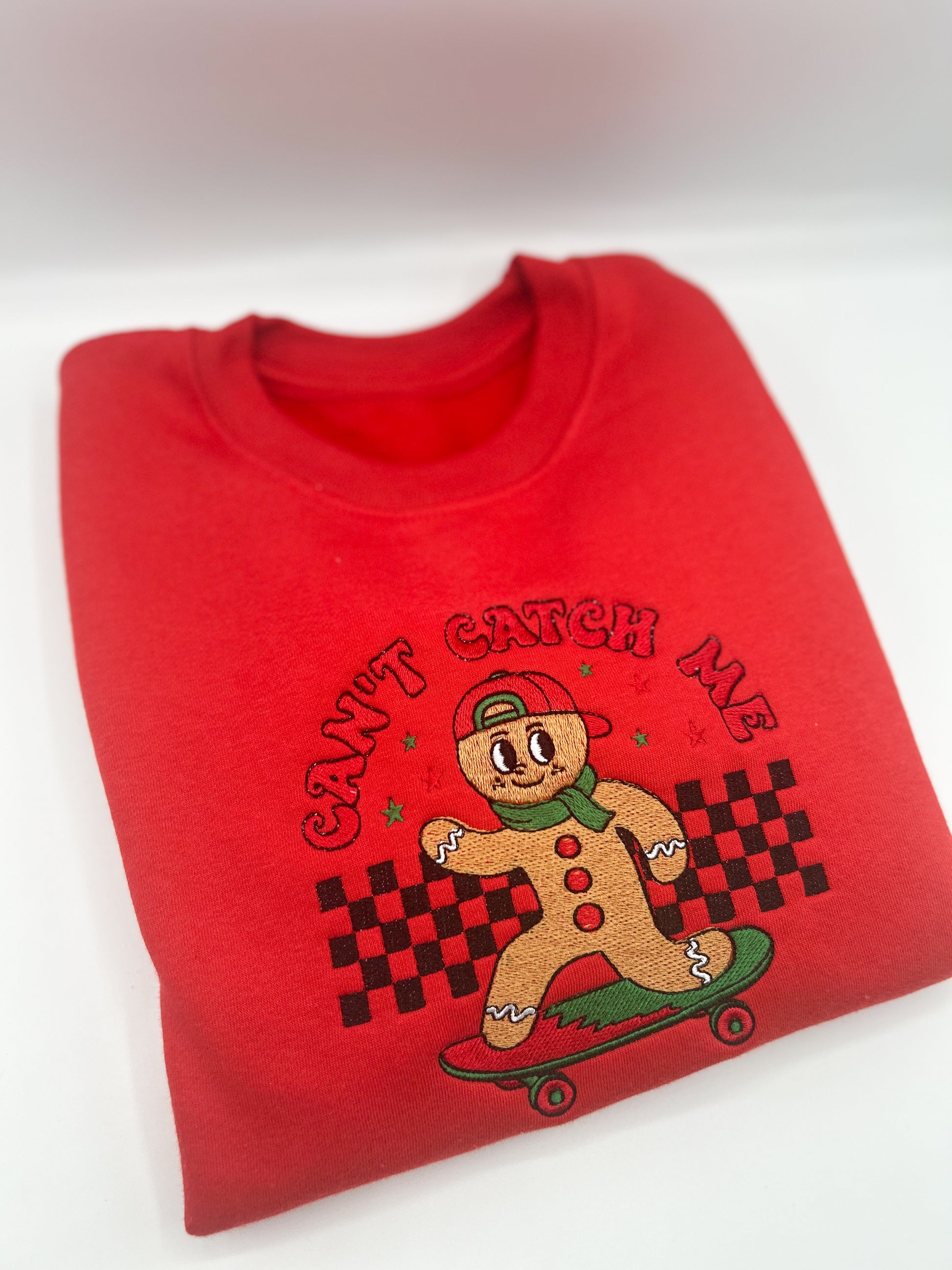 Red Kids Embroidered sweater with a gingerbread man on a skateboard featuring the words "Can't Catch Me"