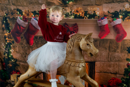 Embroidered kids knit sweater , personalised with the childs name, a star and the words believes in the magic. 