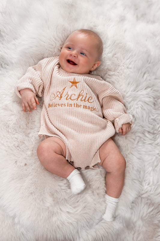 Beige Personalised baby romper with a star embroidery design with the words believes in the magic 