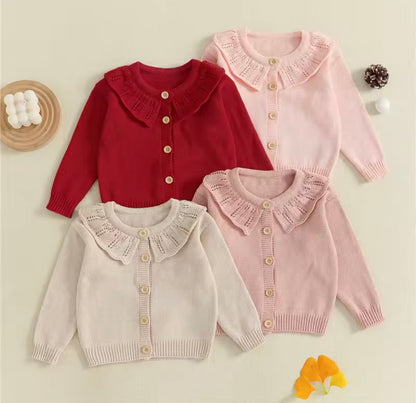 Four children's cardigans in red, pink, and beige with ruffled collars on a light background.