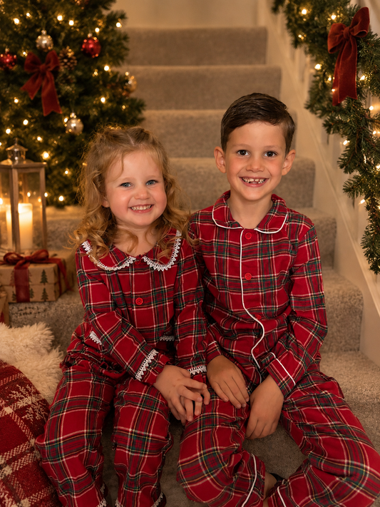 Two kids in tartan style button down pjs personalised with their name 